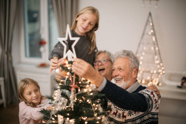 istock Happy family decorating a Christmas tree with ornaments 1279885879