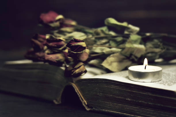 istock Memorial candle, book and dry roses 1279886854