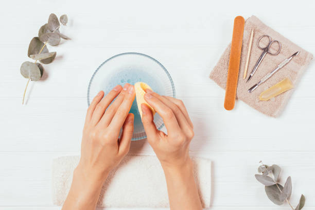 mani da donna che puliscono le unghie con spugna e acqua saponata - water lime foto e immagini stock