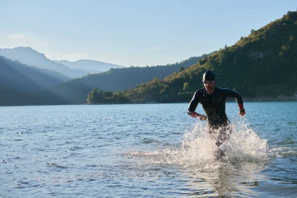 triathlon athlete start swimming training splashing water while running and jumping