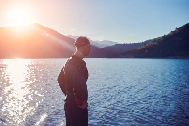 istock triathlon athlete starting swimming training on lake 1279888652