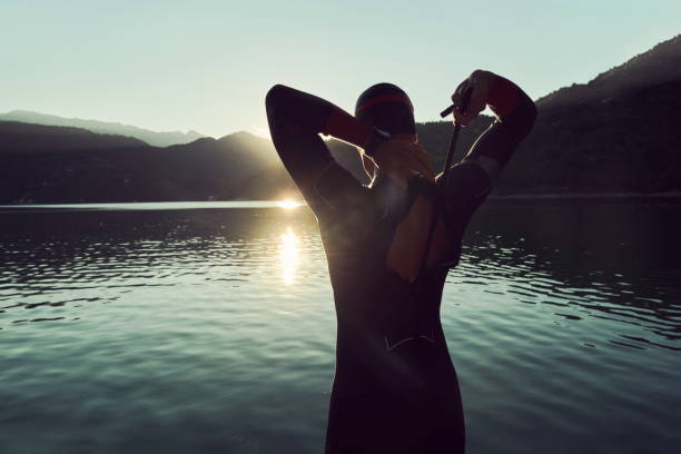 istock triathlon athlete starting swimming training on lake 1279888674