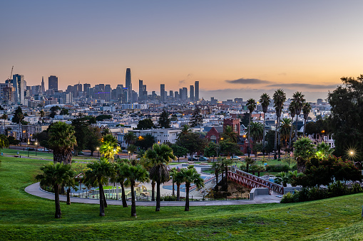 The sun rises over the San Francisco skyline from Mission Dolores Park.