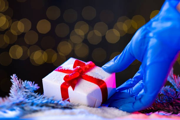 istock christmas covid-19 gift surprise female hand 1279895718