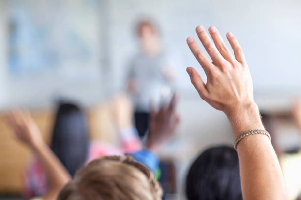istock Teenage student raising hand in classroom 1279895797