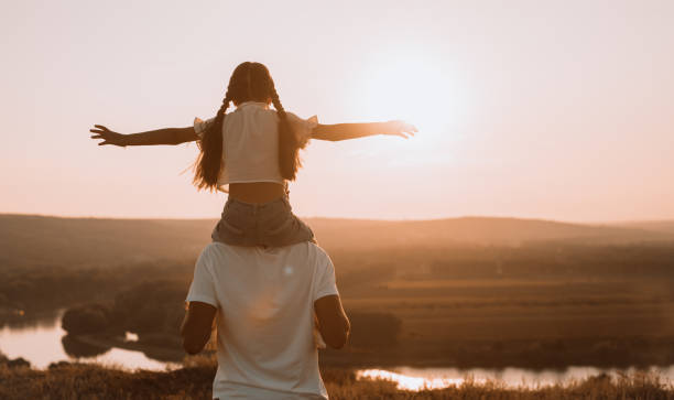 istock Happy father giving daughter shoulder ride and having fun 1279895902