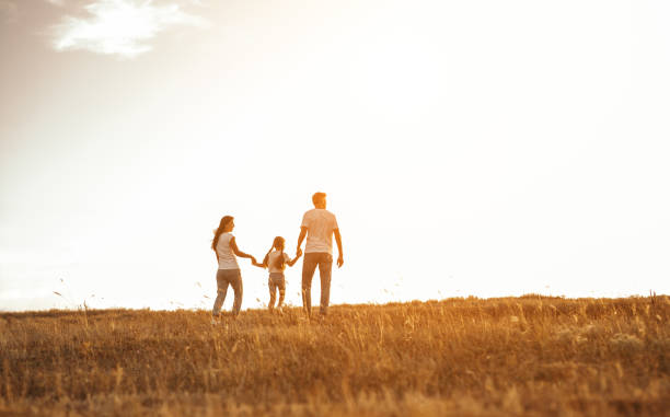 istock Family on walk in field holding hands 1279895909