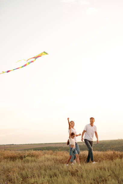 istock Happy family with kite walking in meadow 1279895913