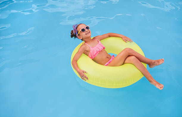 istock Happy child lounging on float in pool 1279895945