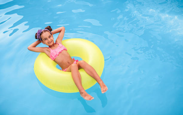 istock Happy girl floating on pool water 1279895949