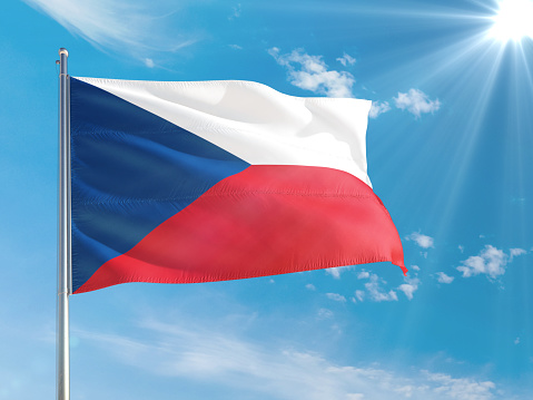 Czech Republic national flag waving in the wind against deep blue sky. High quality fabric. International relations concept.