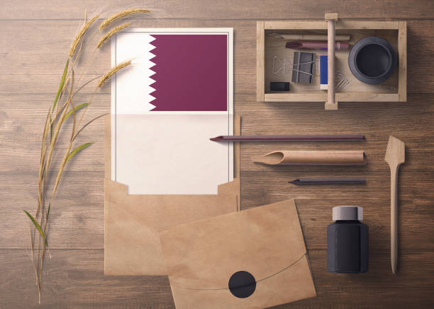 istock Qatar invitation, celebration letter concept. Flag with craft paper and envelope. Retro theme with divide, ink, wooden pen objects. 1279896432