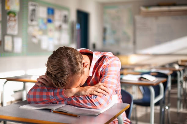 studente adolescente preoccupato e stanco che riposa sul libro alla scrivania - sleeping high school desk education foto e immagini stock
