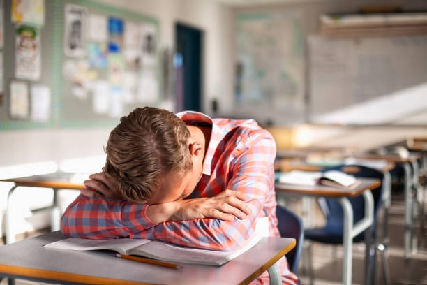 estudante adolescente preocupado e cansado descansando em livro na mesa - sleeping high school desk education - fotografias e filmes do acervo