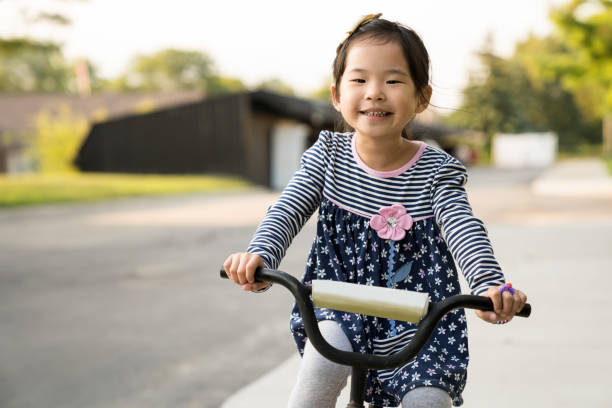 istock Cute little girl learning ride a bicycle with no helmet 1279897727
