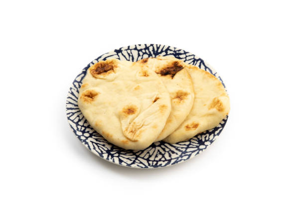 istock Naan bread on a blue plate isolated on a white background 1279898376