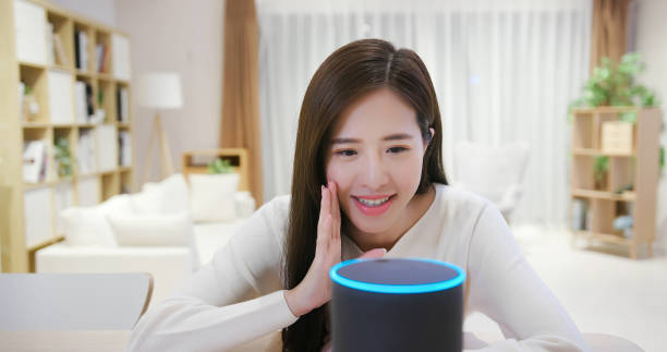 Smart AI speaker concept Smart AI speaker concept - asian young woman talk to voice assistant at home happily virtual assistant stock pictures, royalty-free photos & images