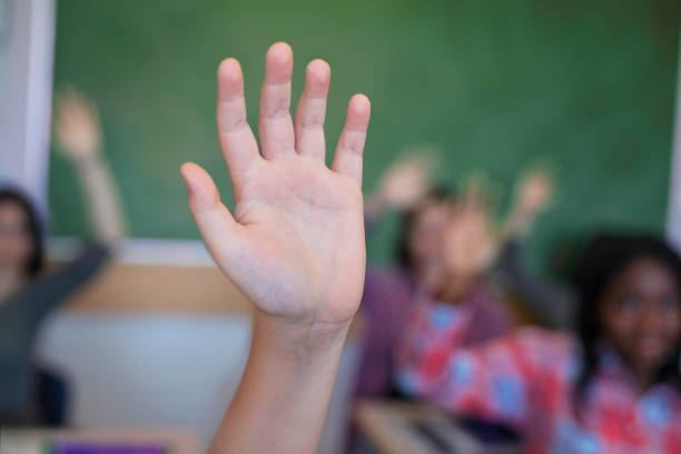 istock School students with hand raised in lecture hall 1279902557