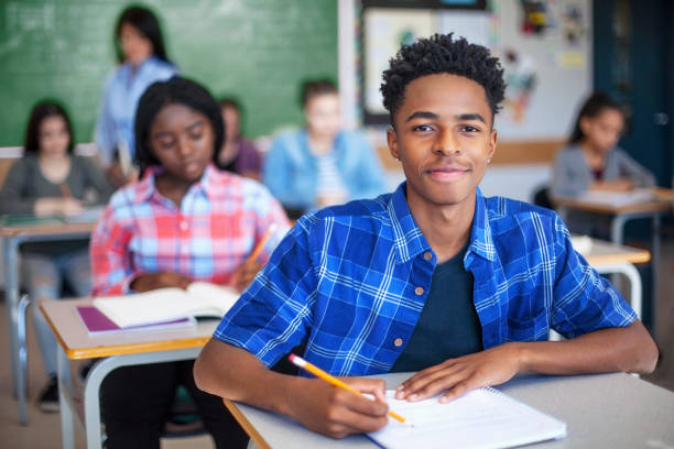 istock Portrait of confident Black ethnicity student writing in classroom 1279902653