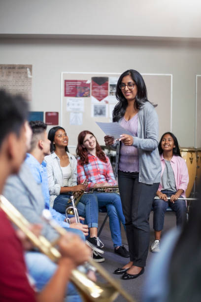 istock Smiling Indian female tutor with students in music band class 1279908509