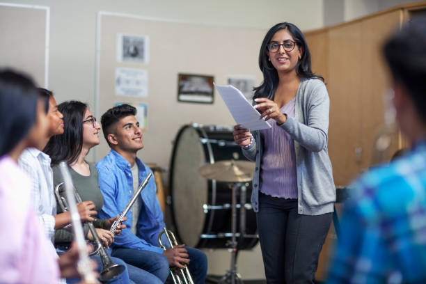 istock Smiling Indian female tutor with students in music band class 1279908556