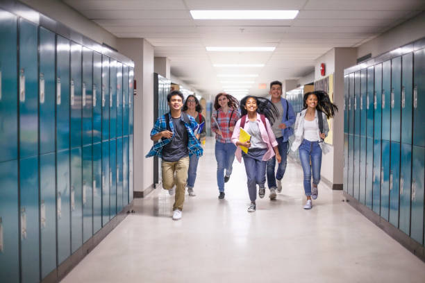 istock Diverse multi-ethnic teenage students running in hallway at school 1279908832