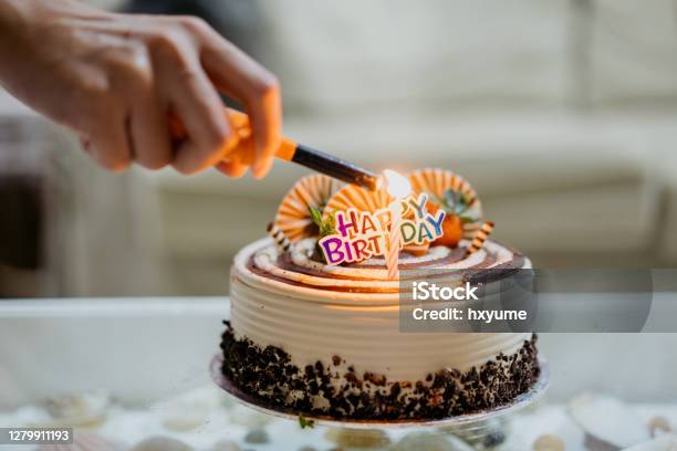 Asian Woman Lighting Up Candle On Birthday Cake Stock Photo - Download Image Now - Happiness, Adult, Adults Only