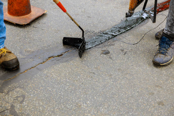 istock Road surface restoration work in the worker performs on road patcher work on the repair of cracks by filling and sealing with coated by bitumen emulsion 1279914213
