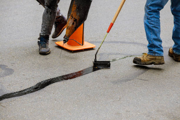 Road surface restoration work in the worker performs on road patcher work on the repair of cracks by filling and sealing with coated by bitumen emulsion Road surface restoration work in the worker performs on road patcher work on the repair of cracks by filling and sealing with coated by bitumen emulsion asphalt surface. asphalt stock pictures, royalty-free photos & images