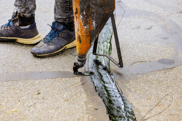 istock Sealing joint crack in asphalt road surface restoration work. 1279914223