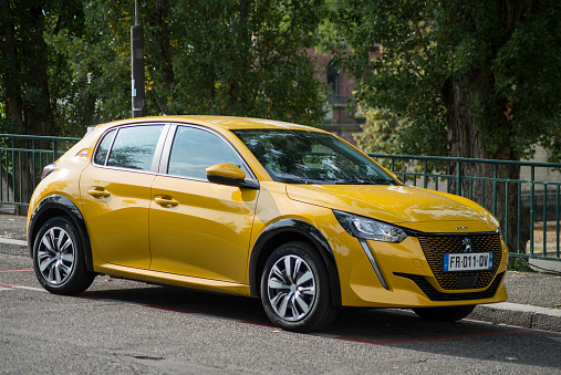 Mulhouse - France - 24 September 2020 - Profile view of Yellow Peugeot 208 electric parked in the street