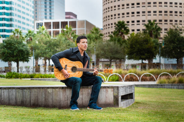 istock Young college student playing guitar in the public park; 1279916064