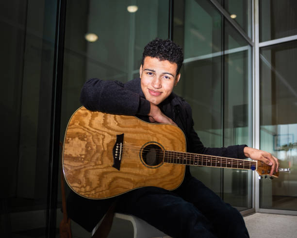 istock Young male musician leaned on his guitar while resting before his street performance 1279916085