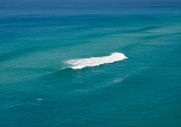 istock Single white wave on a calm blue turquoise sea 1279916166