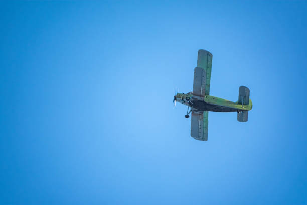 istock Retro green biplane plane in the blue sky 1279917248