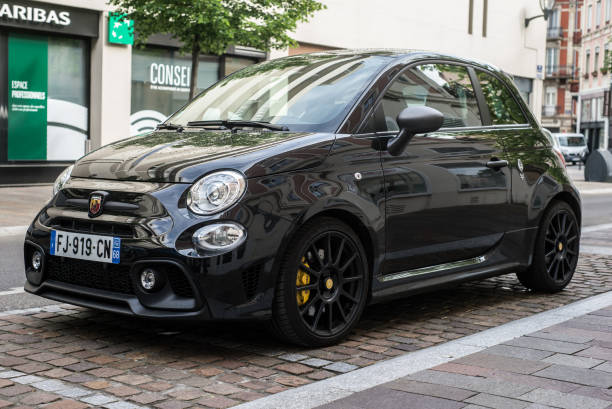 Front View of black Abarth 595 parked in the street Mulhouse - France - 28 April 2020 - Front View of black Abarth 595 parked in the street little fiat car stock pictures, royalty-free photos & images