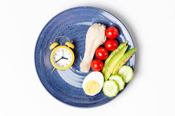 istock Plate with food and alarm clock, intermittent fasting concept. 1279928632
