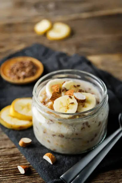 Banana flax seeds overnight oats with banana slices and almonds. toning. selective focus