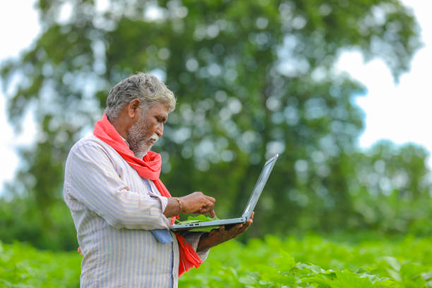 istock Indian farmer using a laptop at agriculture field 1279933340