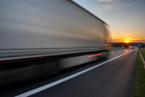 istock truck speeding up on the highway going towards the setting sun 1279934312