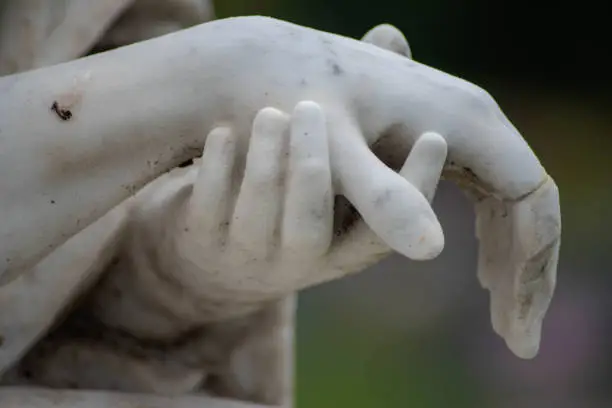 Victorian cemetery pieta hands of Jesus and Mary in white stone. Full frame, shot in natural light with copy space.