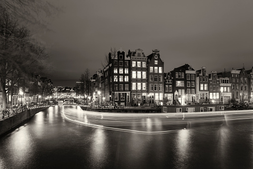 City canal with light trails at night in Amsterdam, Netherlands