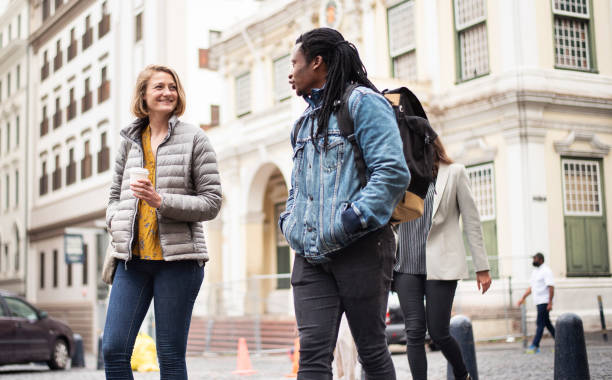 istock Smiling group of diverse friends talking while walking in the city 1279941691