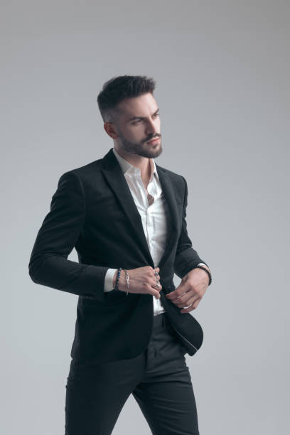 istock Confident elegant man adjusting his jacket and walking 1279941732