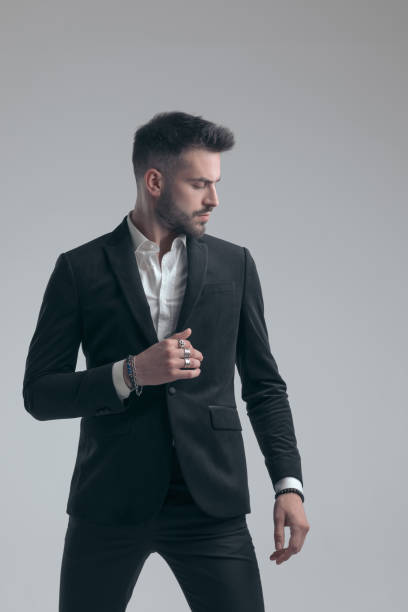 istock Charming elegant man fixing his jacket and looking away 1279941754