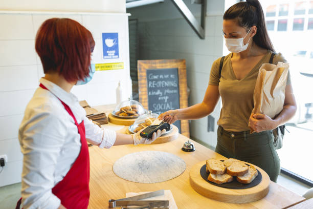 istock Young woman using contact less payment in bakery during Corona virus 1279942085