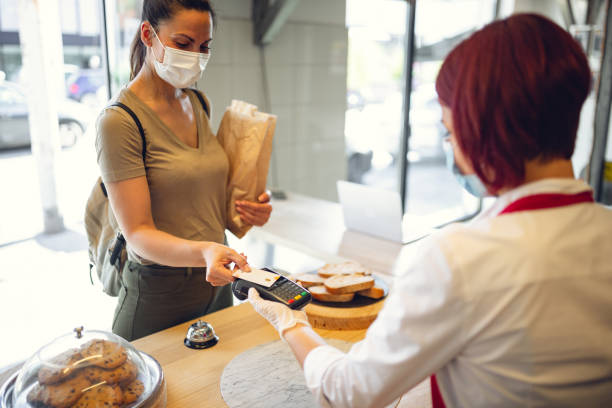 istock Young woman using contact less payment in bakery during Corona virus 1279942179