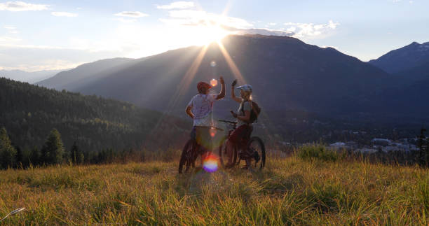 istock Mountain e-biking couple high five in alpine meadow 1279943387