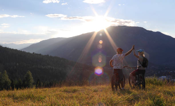 istock Mountain e-biking couple high five in alpine meadow 1279944091