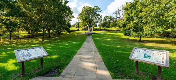 Panoramic of  the monument to the democratic legacy of the Magna Carta with information boards in foreground at Runnymede with no people, Old Windsor, Surrey